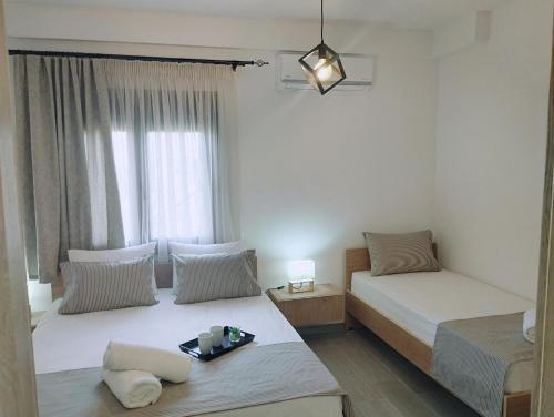 a bedroom with two beds and a window at GRAMMENOS HOUSE in Agios Nikolaos