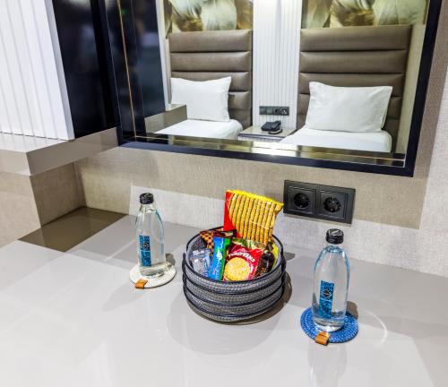 a bathroom with a basket of candy and two bottles at Dem Premium Hotel - Round Trip Airport Service - Istanbul International Airport in Arnavutköy