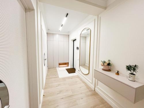 a hallway with white walls and a mirror at ЖК "4You" one room apartment in Almaty