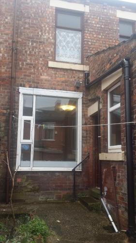 una casa de ladrillo con una ventana y una puerta en Blackburn - Great prices, best rooms, nice place ! en Blackburn