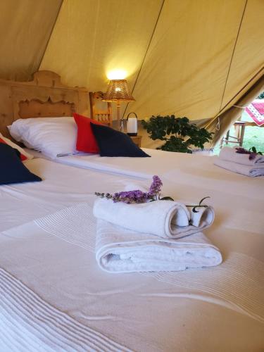 two beds in a tent with towels on them at Tiszaglamping, the belgian hideaway in Tiszacsege