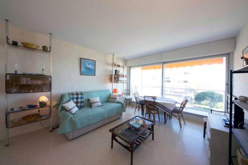 un salon avec un canapé et une table dans l'établissement Nice studio on the seafront, à Arcachon