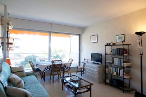 un salon avec un canapé, une table et une télévision dans l'établissement Nice studio on the seafront, à Arcachon
