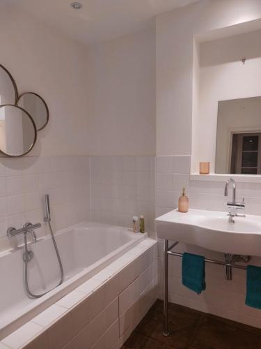 une salle de bain blanche avec une baignoire et un lavabo dans l'établissement Vakantiehuis Domaine de Nazac, à Saint-Sulpice