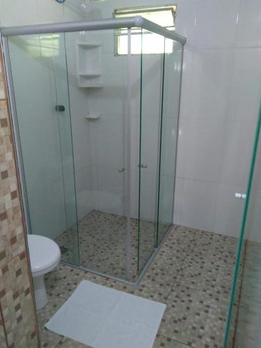 a bathroom with a glass shower with a toilet at Pousada Pérola do Atlântico in Ilha de Boipeba