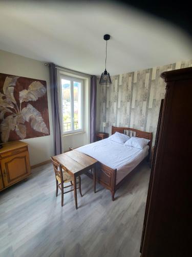 une chambre avec un lit, une table et une fenêtre dans l'établissement Appartement confortable à La Bourboule, 64 m², balcons agréables, à La Bourboule