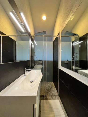 a bathroom with a sink and a glass shower at Wohnung mit grossartiger Seesicht und Balkon in Spiez