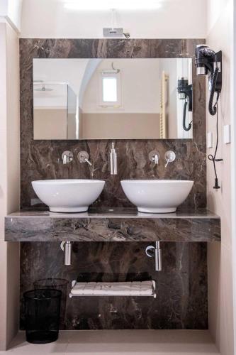 a bathroom with two sinks and a mirror at Palazzo Bove 2 - Villa Dagmar in Galatone