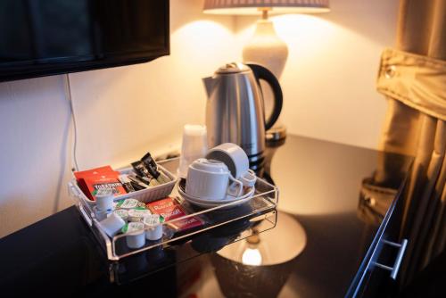a tray with cups and a coffee maker on a table at Ewenny Farm Guest House in Bridgend