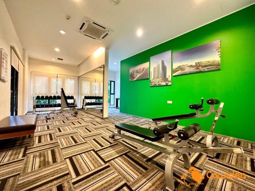 a gym with a green wall and a treadmill at DangaBay in CountryGarden - Fantastic2 #Cowidea in Johor Bahru