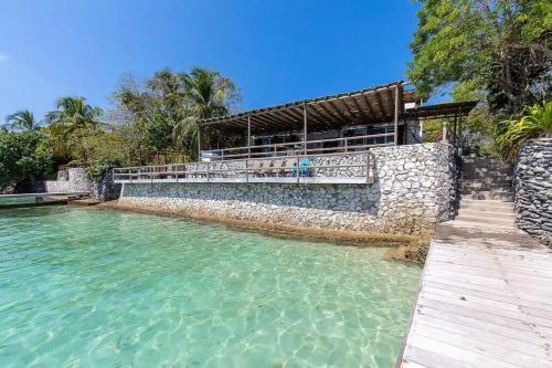 una piscina de agua junto a un edificio de piedra en Wonderful House Paradise in the Rosario Islands, en Cartagena de Indias