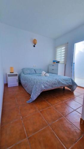 a bedroom with a bed and a tiled floor at El poniente in Caleta de Sebo