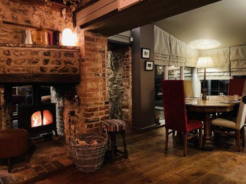 a dining room with a table and a fireplace at The Greyhound Inn in Dorchester