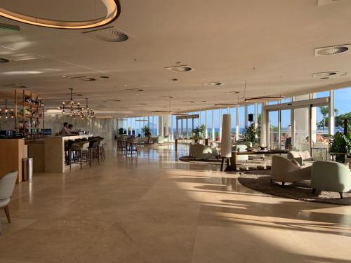 un gran vestíbulo con sillas, mesas y ventanas en Hotel Nacional RJ - Vista Mar, en Río de Janeiro