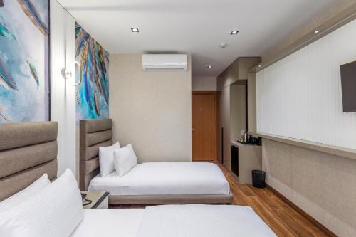 a hotel room with two beds and a tv at Dem Premium Hotel - Round Trip Airport Service - Istanbul International Airport in Arnavutköy