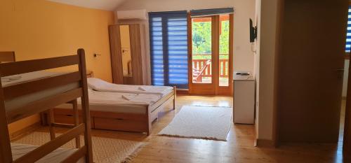Cette chambre comprend 2 lits superposés et une porte donnant sur un balcon. dans l'établissement Apartmani,kucice DRINA-BOK, à Ljubovija