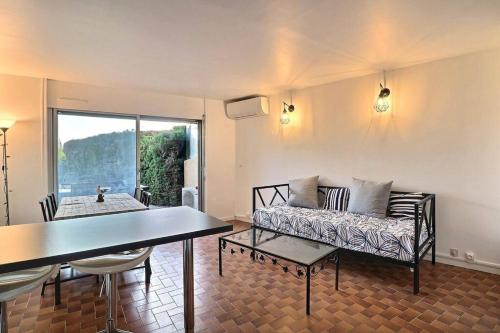 un salon avec un canapé et une table dans l'établissement Petit coin de paradis à deux pas de la mer jardin, à La Ciotat