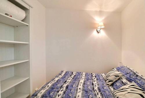 une chambre avec un lit et une étagère dans l'établissement Petit coin de paradis à deux pas de la mer jardin, à La Ciotat