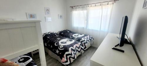 a bedroom with a bed and a desk with a computer at Chacras del Mar - Acceso exclusivo vehiculo 4 x 4 in Mar Azul