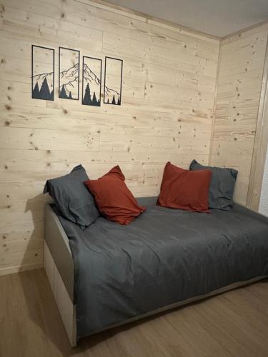 a bed with three pillows on it in a room at Studio « Le petit montagnard » in Malbuisson