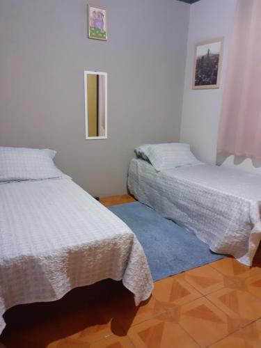 um quarto com 2 camas e um tapete azul em Casa/chale Campos do Jordao em Campos do Jordão