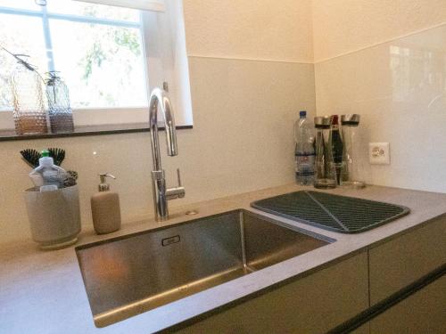une cuisine avec un évier en acier inoxydable et une fenêtre dans l'établissement Exclusive Unterkunft in 15min bis Hallenstadion - Zürich City - Flughafen ZH, à Rümlang