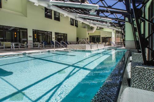 a large swimming pool with blue water in a building at DoubleTree by Hilton Deadwood at Cadillac Jack's in Deadwood