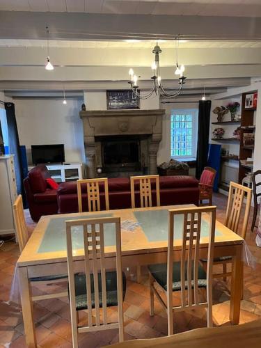 - un salon avec une table, des chaises et une cheminée dans l'établissement P’tite Raguenne, à Plouha
