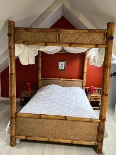 - une chambre avec un lit à baldaquin et des draps blancs dans l'établissement P’tite Raguenne, à Plouha