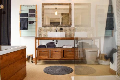 une salle de bain avec un lavabo et un miroir dans l'établissement Le Nid, à Lanloup