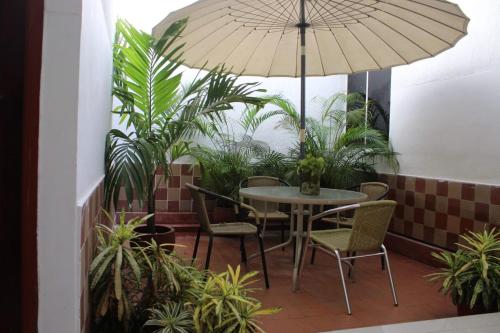 un patio con mesa, sillas y sombrilla en Hotel Palma Real Cartagena, en Cartagena de Indias