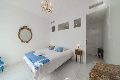 une chambre blanche avec un lit et un miroir dans l'établissement Wdf 2 bedrooms heart of Cannes, à Cannes