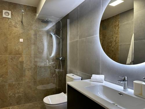 bagno con lavandino, servizi igienici e specchio di Sunsets Sur Ponderosa a Playa Fañabe