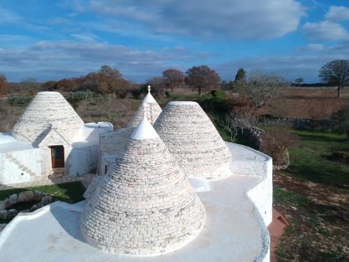a group of white structures with trees in a field at Masseria Dirupo in Noci
