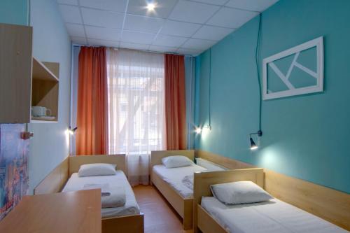 Habitación con 2 camas, mesa y ventana en Hostel Podolski Plus, en Kiev