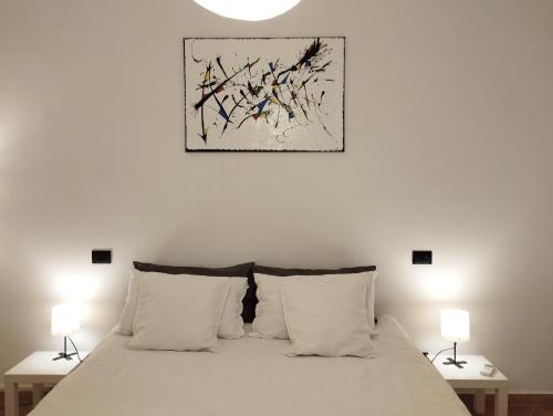 een slaapkamer met een wit bed en 2 lampen bij OLD TOWN HOUSE LA CORTE Casa Vacanze in Civita Castellana