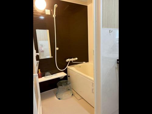 een badkamer met een bad, een wastafel en een spiegel bij Okasan Hotel - Vacation STAY 60555v in Ogaki