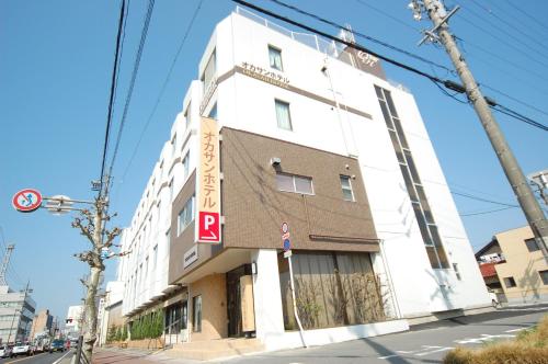 een hoog wit gebouw op een straathoek bij Okasan Hotel - Vacation STAY 60555v in Ogaki