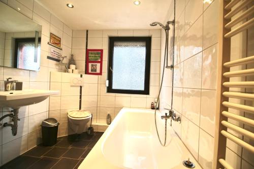 a bathroom with a tub and a sink and a toilet at Pension Decker in Zirndorf