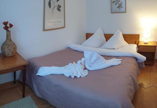 a bed with white sheets and pillows on it at Azuga Apartament Super View & Ski in Azuga