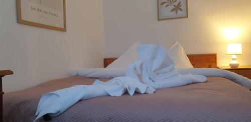 a bed with white sheets and towels on it at Azuga Apartament Super View & Ski in Azuga