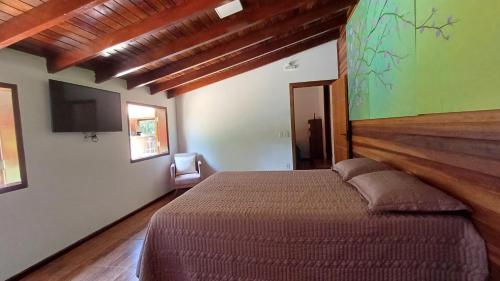 1 dormitorio con 1 cama y TV de pantalla plana en Sítio Encontro das Águas Brotas, en Ibirapuera