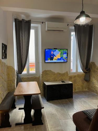 un salon avec une table et une télévision dans l'établissement Logis centre historique 4 personnes - Soleil Levant La Ciotat, à La Ciotat