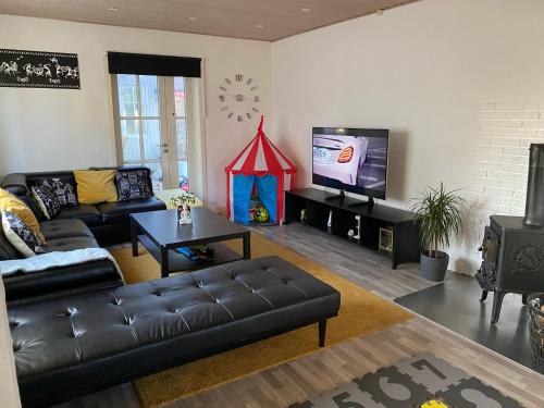 a living room with a couch and a tv at Cozy Heaven! Just 17 min's to Central in Hedehusene