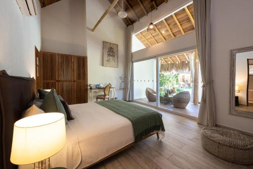 een slaapkamer met een bed en een groot raam bij TAKUMA BOUTIK HOTEL in Las Terrenas