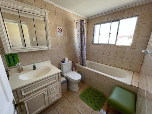 uma casa de banho com um lavatório, um WC e uma banheira em Hostal del Rosario La Serena em La Serena