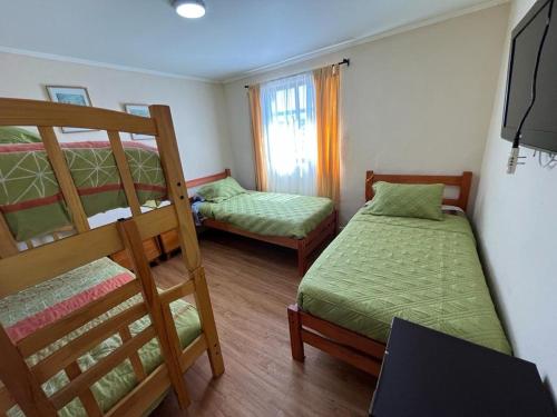 a bedroom with two bunk beds and a staircase at Hostal del Rosario La Serena in La Serena