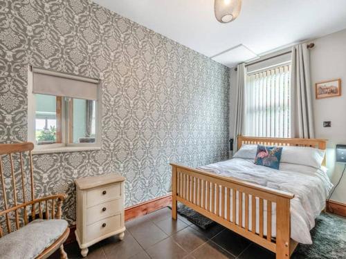 a bedroom with a bed and a window and a crib at Firs Retreat in Balderton