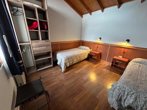a room with two beds in a room with wooden floors at Terra Incognita in Ushuaia