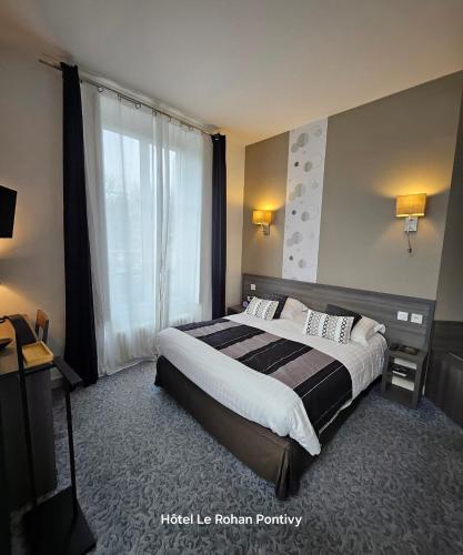 a hotel room with a bed and a window at Hôtel Le Rohan Charme et Caractère in Pontivy